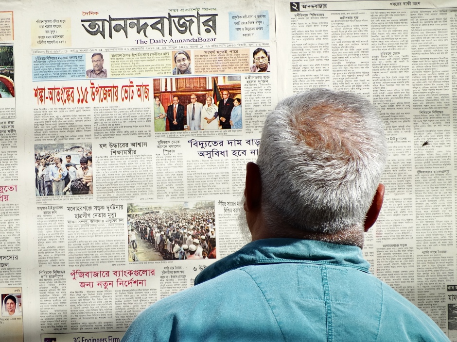 A man reads a newspaper in Dhaka, Bangladesh